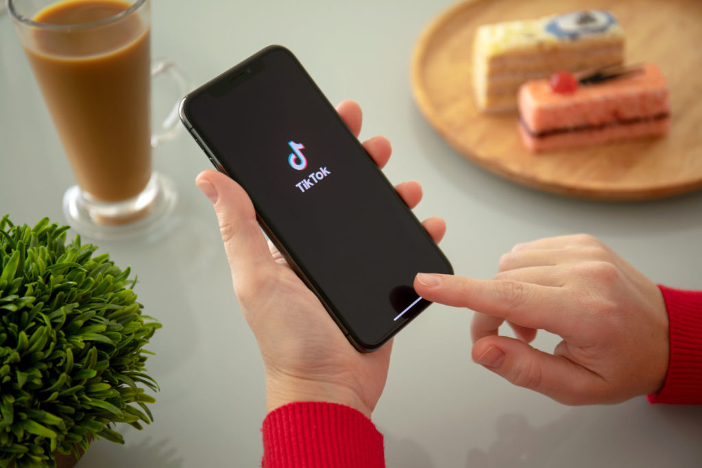 Alushta, Russia - November 6, 2018: Woman holding iPhone X with streaming service media and video TikTok on the screen. iPhone ten was created and developed by the Apple inc.
